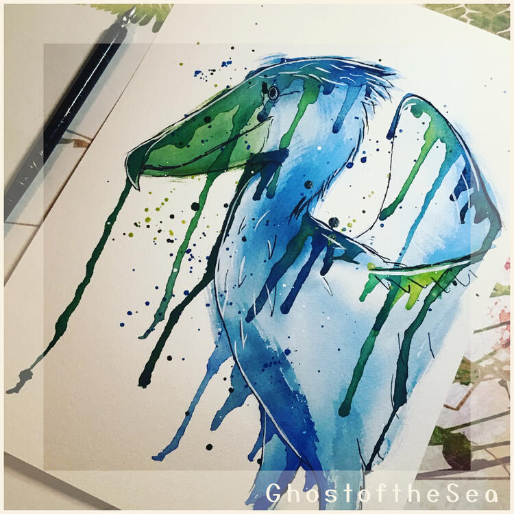 Photo of an A4 watercolour painting of a shoebill stork, in green and blue with splatters and drips of paint around it.
